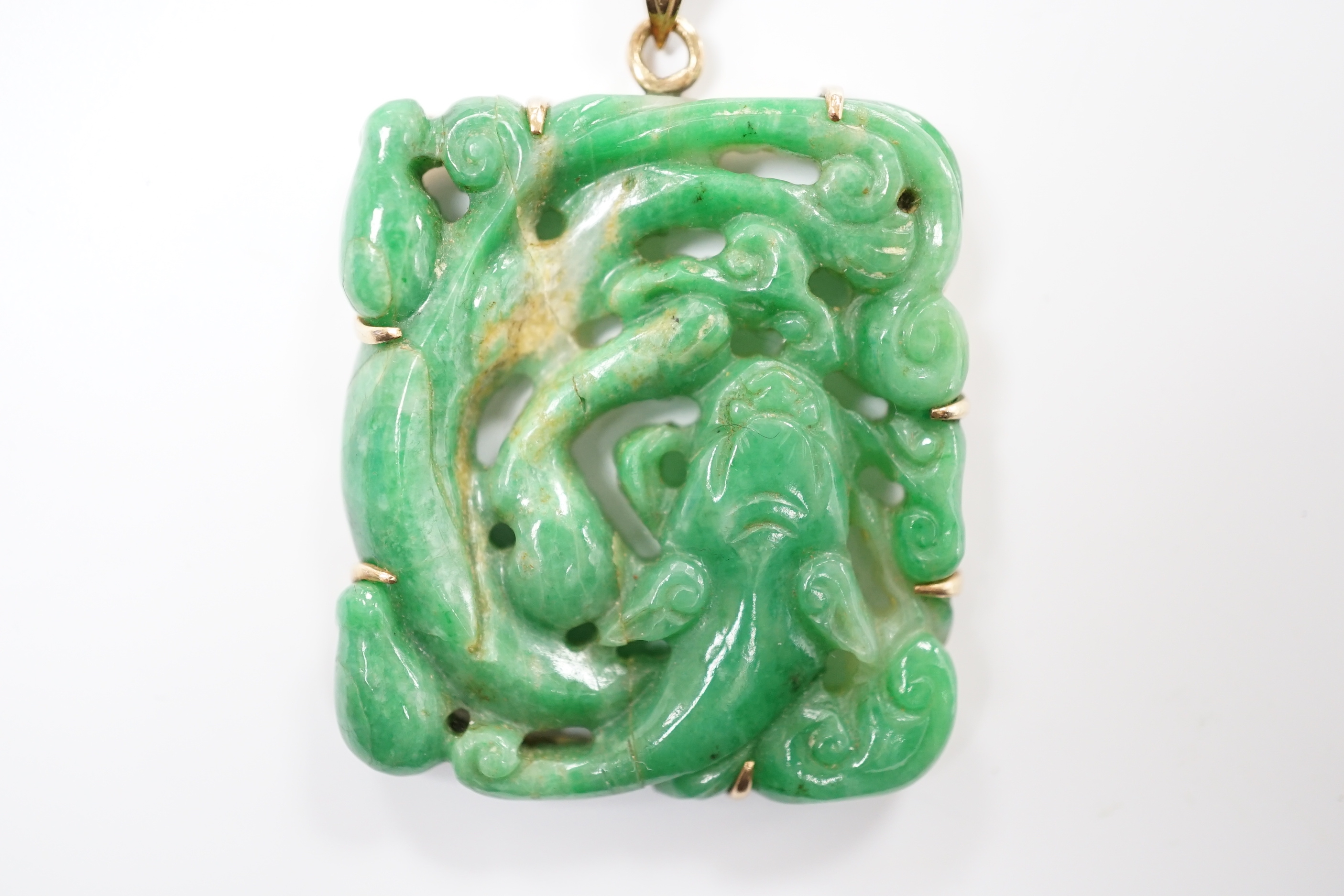 A yellow metal mounted jade pendant, carved with a fish, of square form, 37mm.